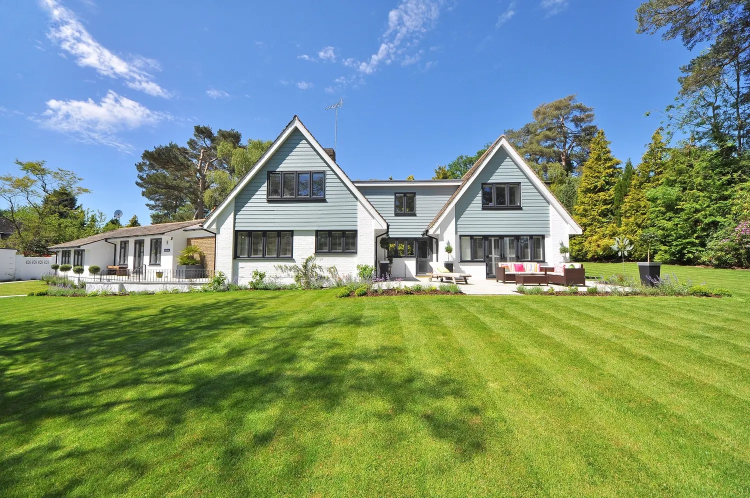 A bright residential home behind a freshly maintained lawn